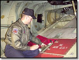 USCG crewman loads flares into the launchers on C-130