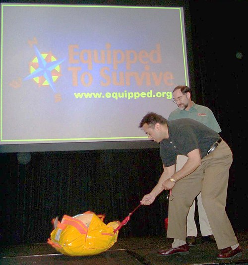 Doug watches carefully as a volunteer deploys a demonstration life raft