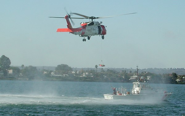 USCG H60 winching litter from small boat